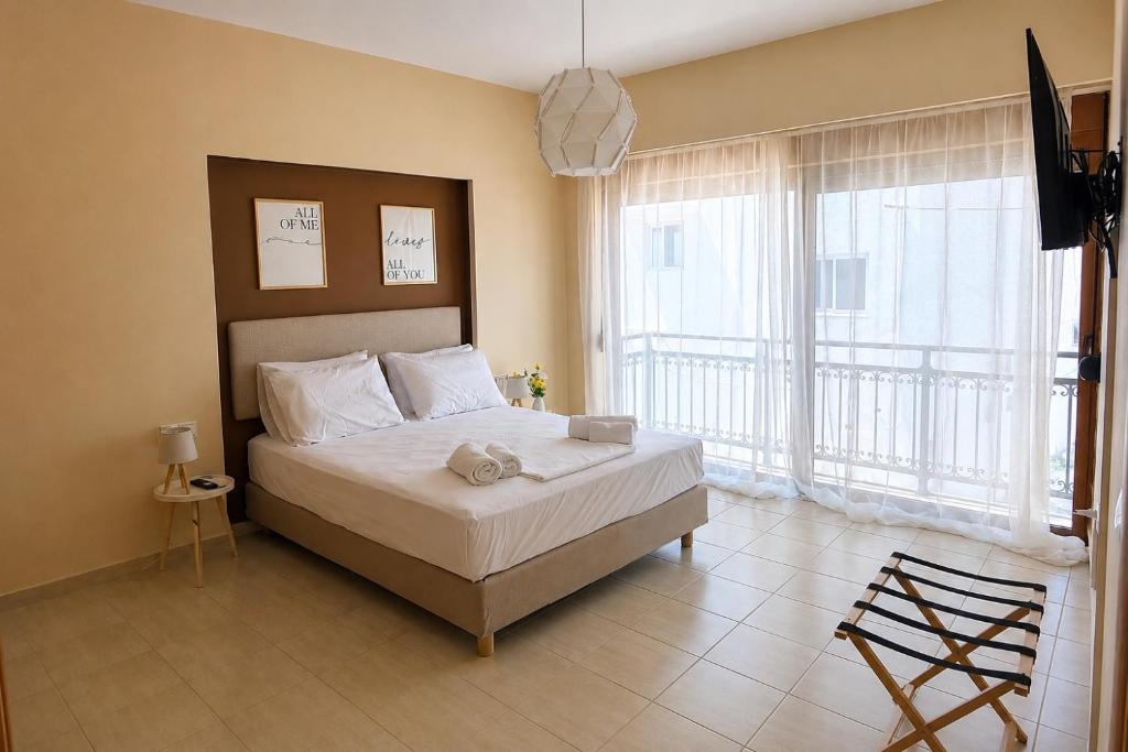 a bedroom with a bed and a large window at Azure Seaside Living in Kardamaina