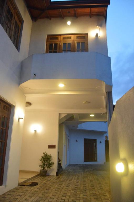 a large white building with a hallway with a staircase at Cinnamon Villa Kandy in Kandy