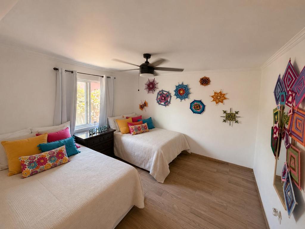 a bedroom with two beds and a ceiling fan at Magic Colombia in El Porvenir