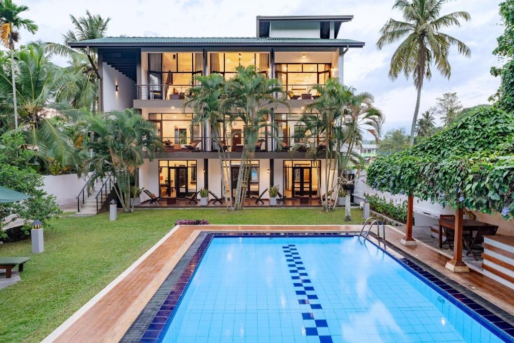 a house with a swimming pool in front of a house at Nature Trails Boutique Hotel in Unawatuna