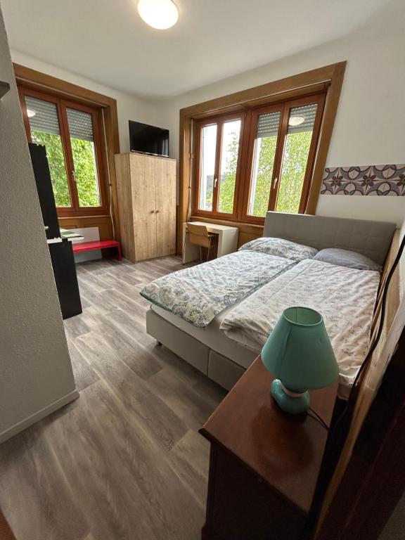 a bedroom with a bed and a table with a lamp at Studio in Tramelan