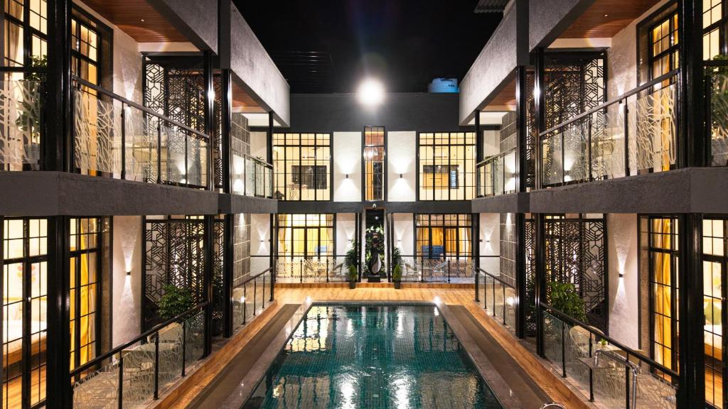 a pool in the middle of a building with windows at Barefoot bliss by iLiF Hotels in Revadanda