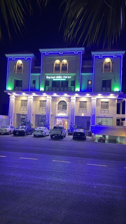 a blue building with cars parked in front of it at شقق برج نوران للشقق المخدومة Nouran Tower Serviced Apartments in Al Khobar