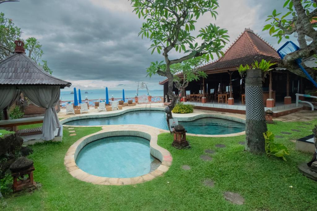 a swimming pool in the yard of a resort at The ARIRAS Resort in Candidasa