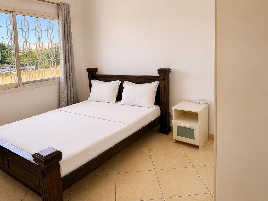a small bedroom with a bed and a window at Appartement 2 chambres in Moroni