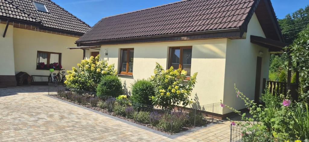 a house with some flowers in front of it at Pod Lasem in Przewłoka