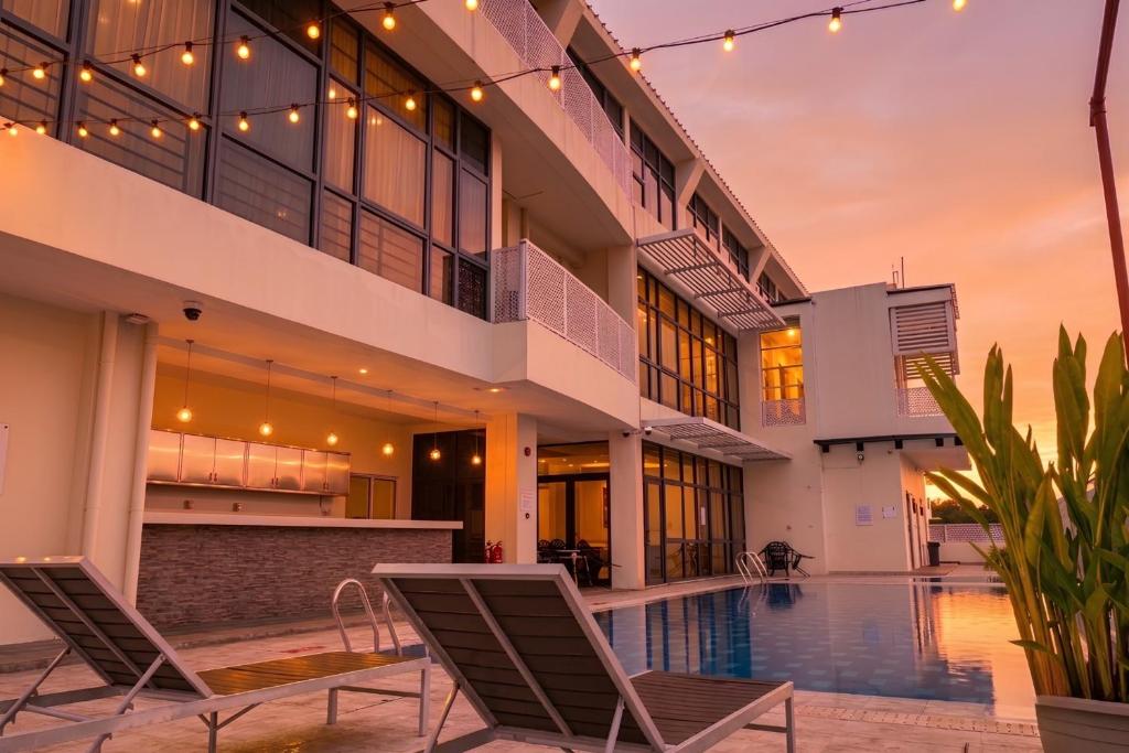 a house with a swimming pool and two chairs at Greenmont Hotel & Apartment in Bandar Seri Begawan