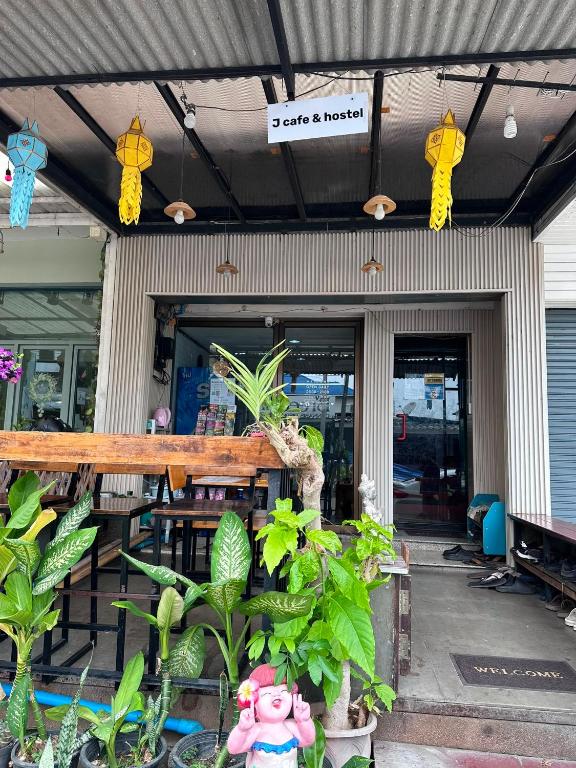 a restaurant with plants in front of a building at J Cafe & Hostel in Chiang Mai