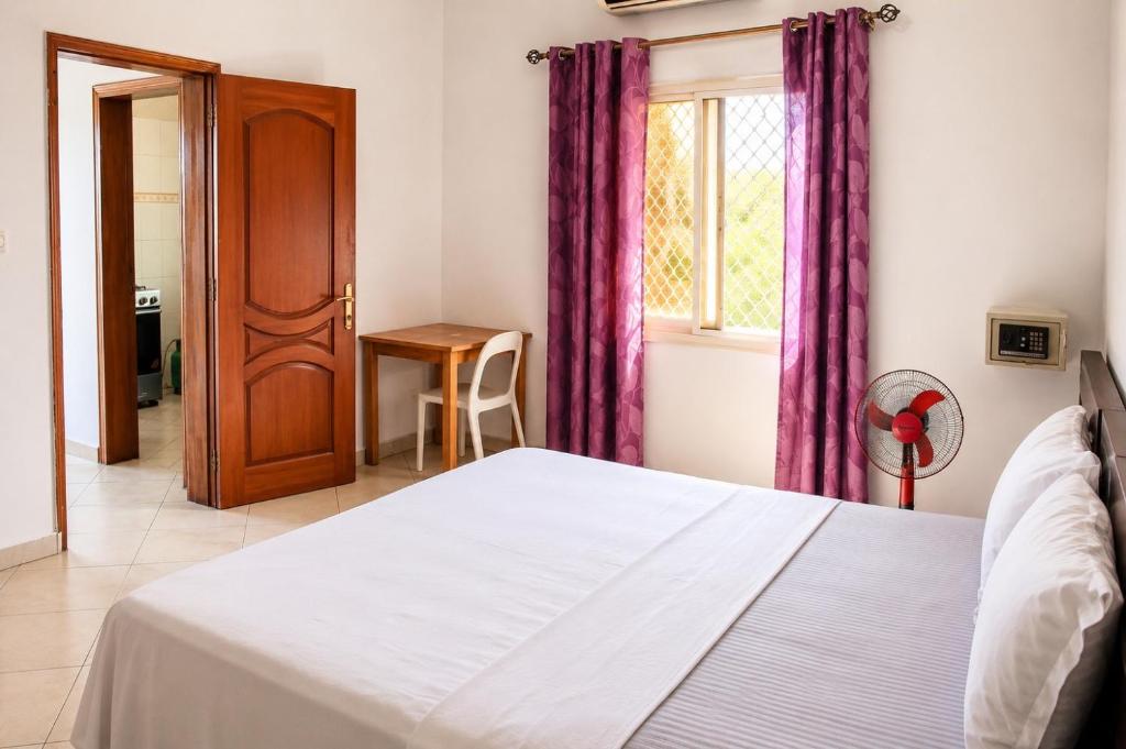 ein Schlafzimmer mit einem Bett und einem Fenster in der Unterkunft Appartement in Moroni