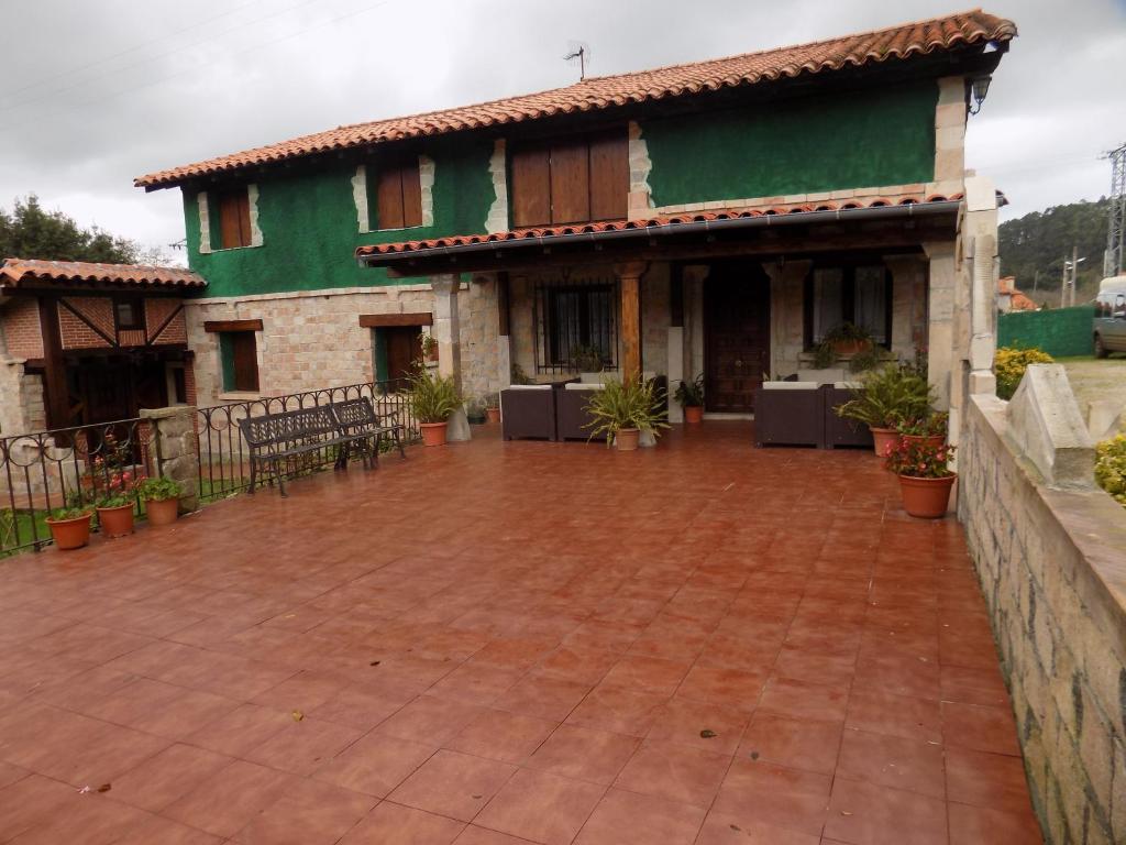 una casa con un patio de ladrillo delante de ella en Posada La Ceña, en Novales