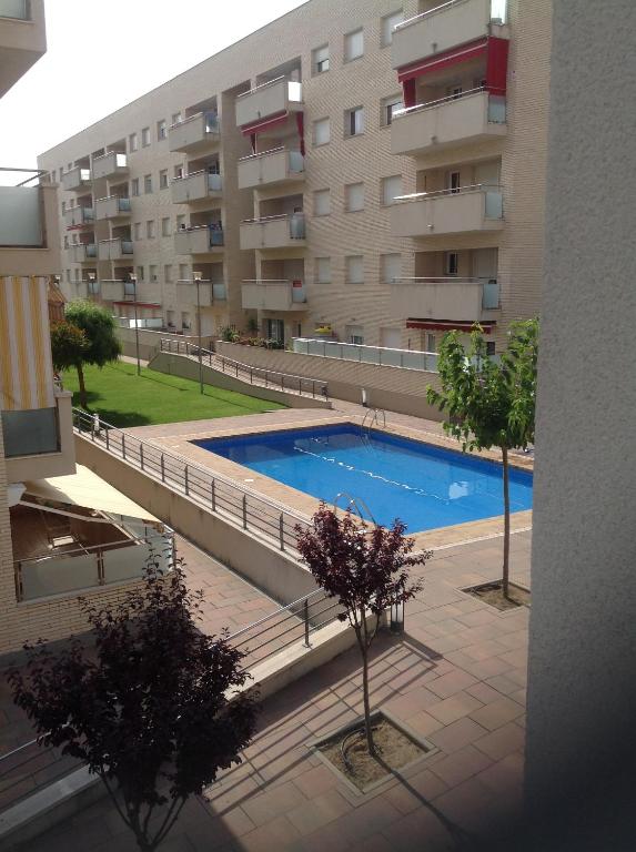 a swimming pool in front of a building at Apartamento Relualhu in Lloret de Mar
