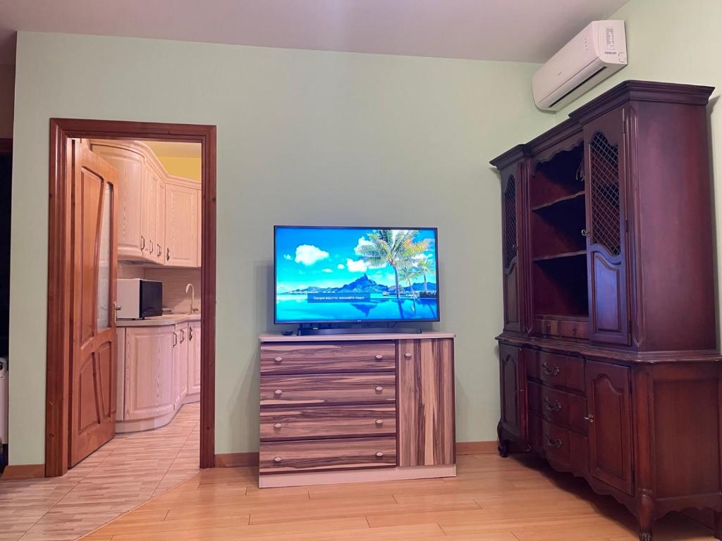 a living room with a television on a wooden dresser at Private Apartment in Morshin