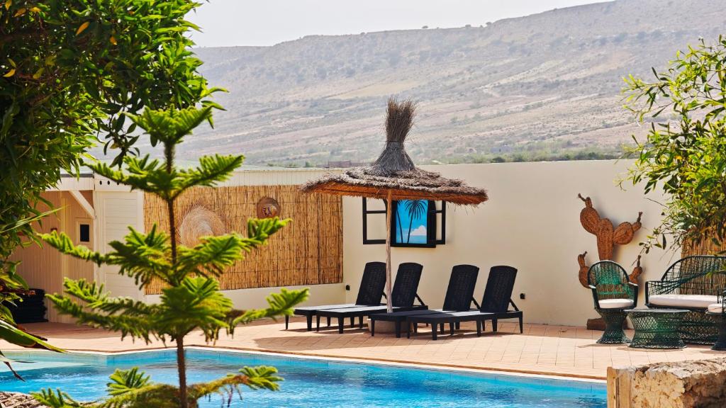 a resort with a pool and mountains in the background at The Mogador's Oasis in Akermoud
