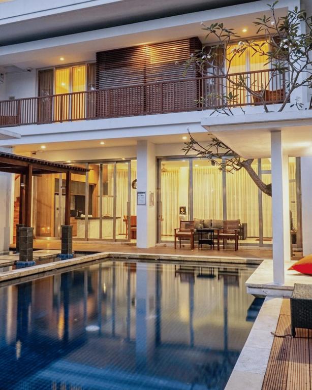 a villa with a swimming pool and a house at The Kharma Villas Yogyakarta in Yogyakarta