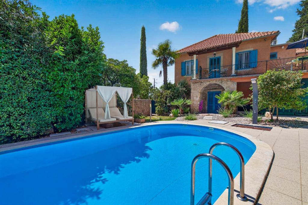 a swimming pool in front of a house at VILLA Mara in Dubravka