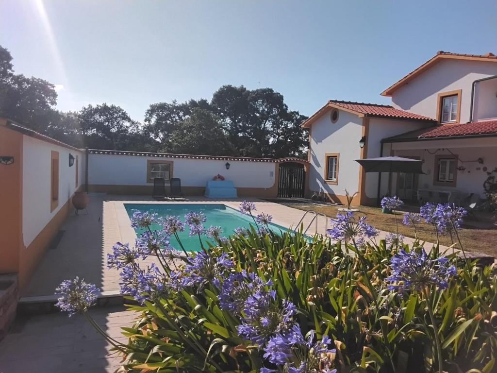 a house with a swimming pool and purple flowers at Sol Lua House in Fátima