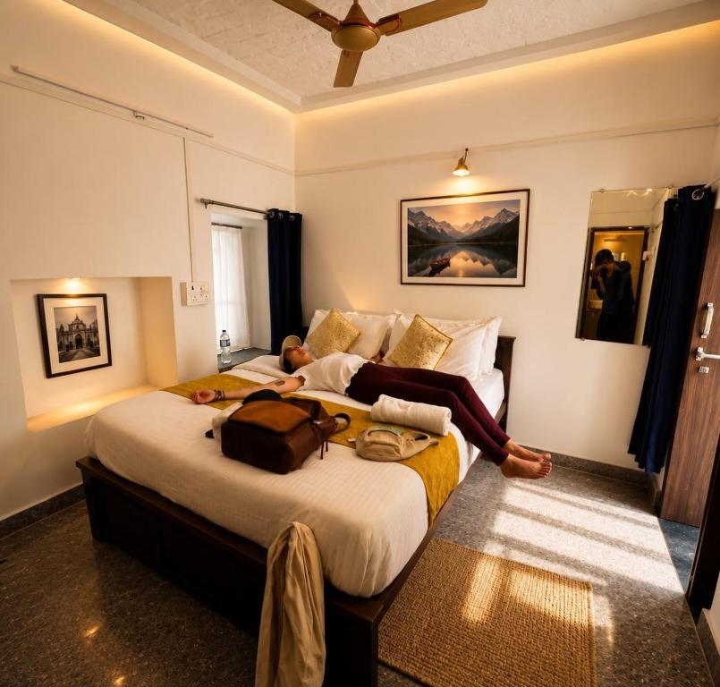 a bedroom with a large bed with a woman laying on it at Hostel Dara Jaisalmer in Jaisalmer