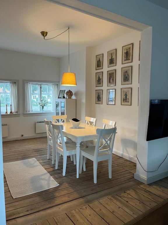 a dining room with a white table and chairs at The South Wing at Højbygård in Rødby