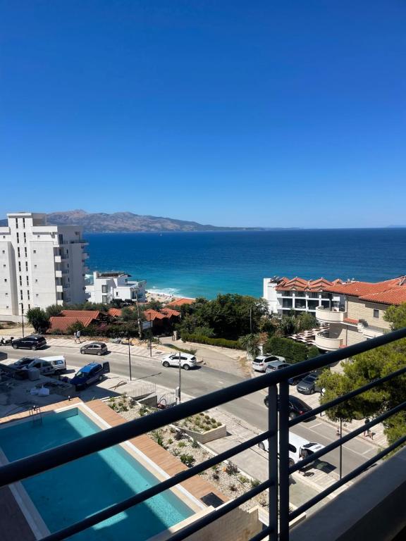 a balcony with a view of a parking lot and the ocean at Miramare Aparthotel in Sarandë