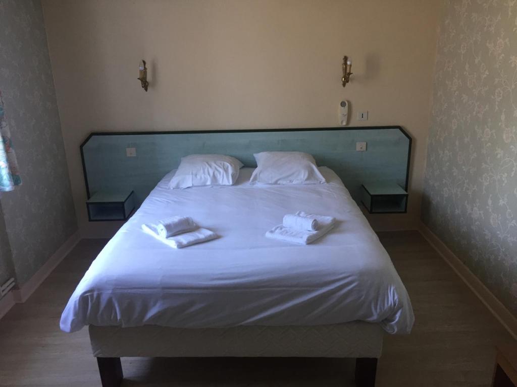 ein großes weißes Bett mit zwei Handtüchern darauf in der Unterkunft Le Lanthenay in Romorantin