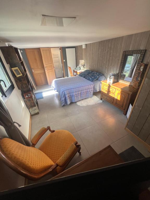 a view of a bedroom with a bed and a chair at Les Angères in Saint-Martin-d'Uriage