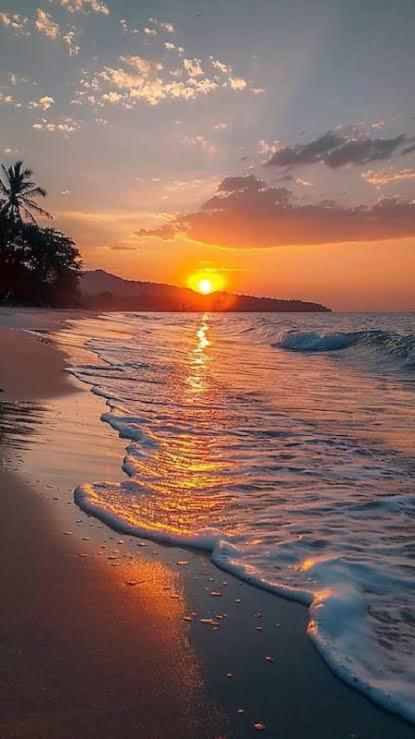 a sunset on a beach with the ocean at Hotel Avenue Calangute in Baga
