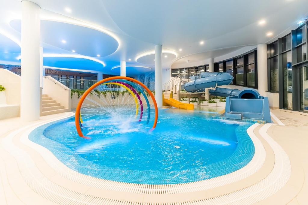 a pool on a cruise ship with a water slide at POLANKI AQUA APARTAMENTY - Aquapark, baseny, wellness, 300 m od plaży in Kołobrzeg