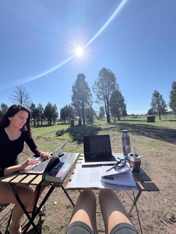 a woman sitting at a picnic table with her laptop at Scrub n bush in Bohena Creek