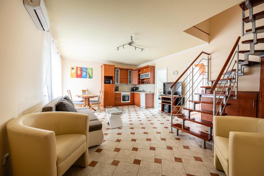 a living room with two couches and a staircase at Gere Apartment de Luxe in Harkány
