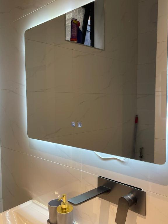 a bathroom with a large mirror above a sink at Bellwether Heights Kyanja in Kampala
