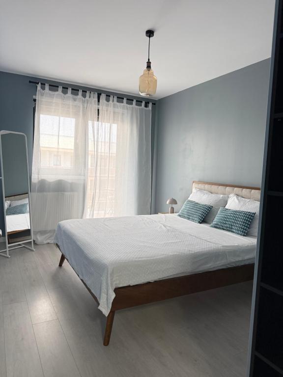 a bedroom with a bed with blue walls and a window at Blue Oasis Apartment - Hils Brauner in Bucharest