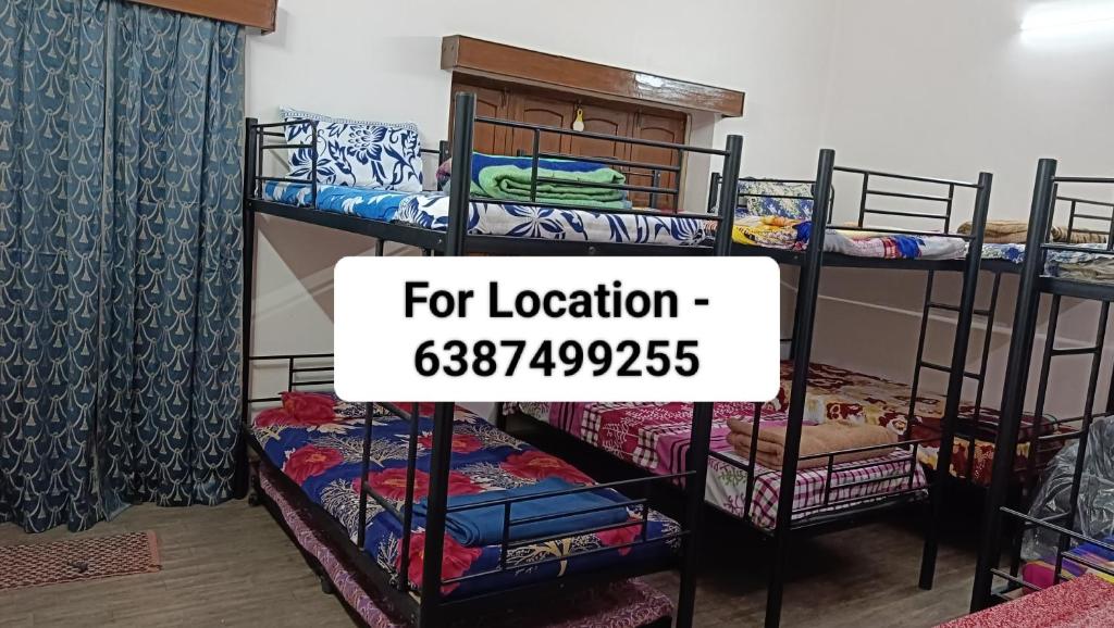 a room with bunk beds with a sign that reads for location at Accommodation In Prayagraj, Near Railway Station Triveni Sangam, Allahabad in Prayagraj