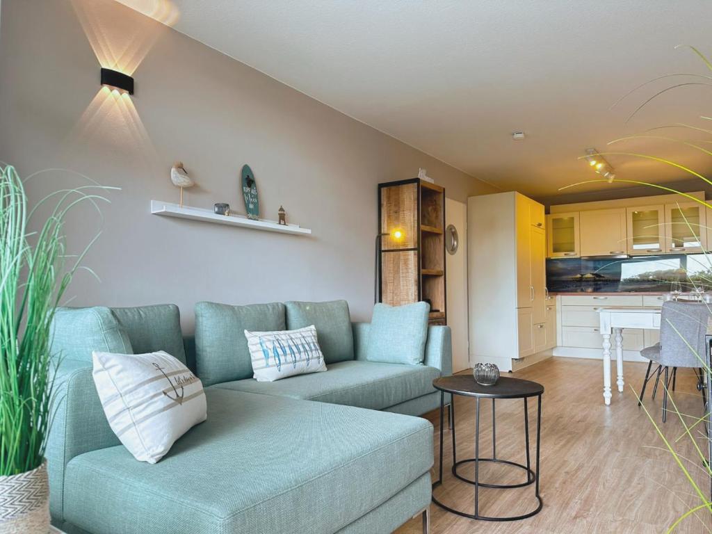 a living room with a couch and a table at Villa Anna I - Wohnung Strandjunge in Sankt Peter-Ording