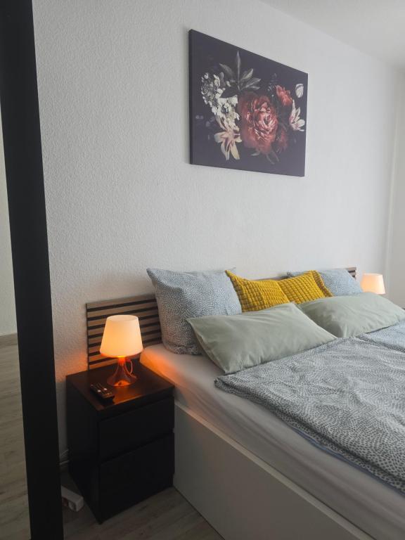 a bedroom with a bed with a lamp on a night stand at Simple Modern Apartment in Duisburg