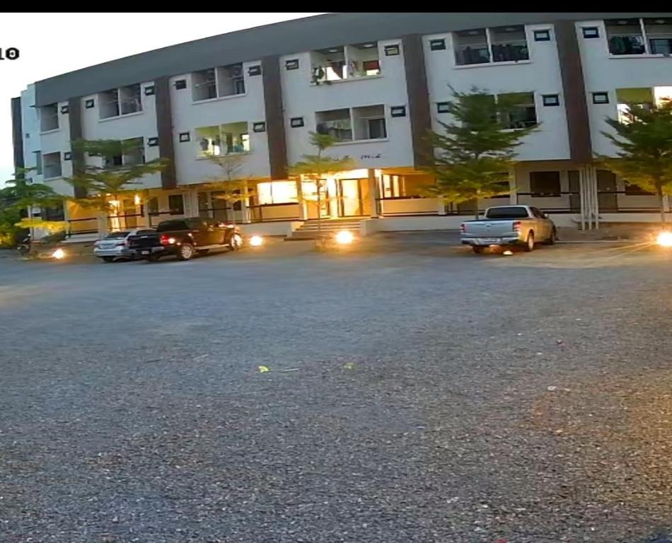 a parking lot in front of a large building at ห้องพัก168 in Ban Amphaeng