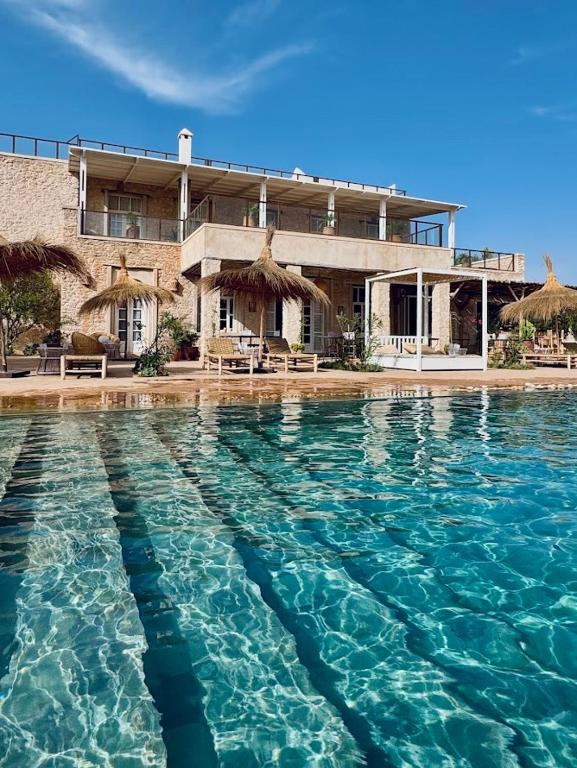 a large pool of water in front of a house at Riad SABIDI in Essaouira
