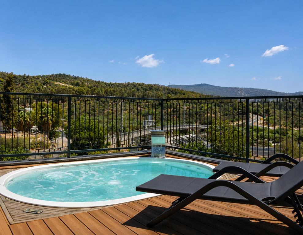 a swimming pool on a deck with two chairs at בוטיק אשתאול - 4 סוויטות מפנקות עם ג'קוזי פרטי ו2 בריכות במתחם in Eshtaol