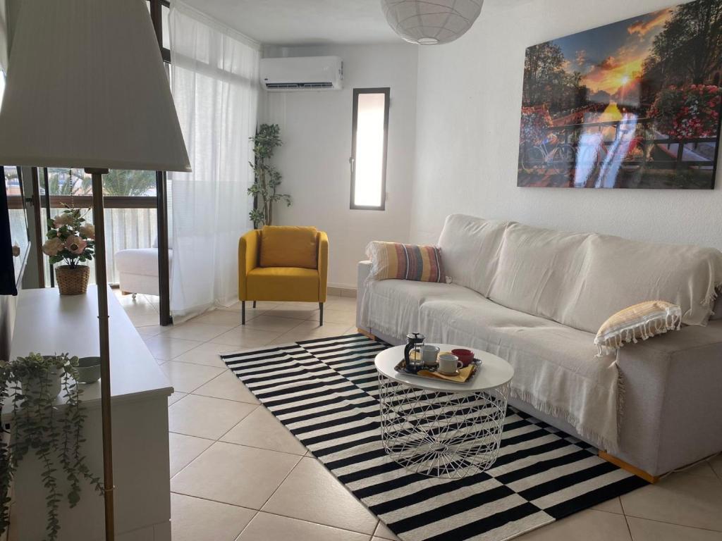 a living room with a white couch and a table at Jandia Beach Apartment in Morro del Jable