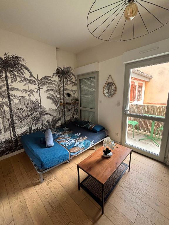 a bedroom with a bed and a table in it at Studio Chic & Balcon - Hypercentre - Gare - Metro in Toulouse