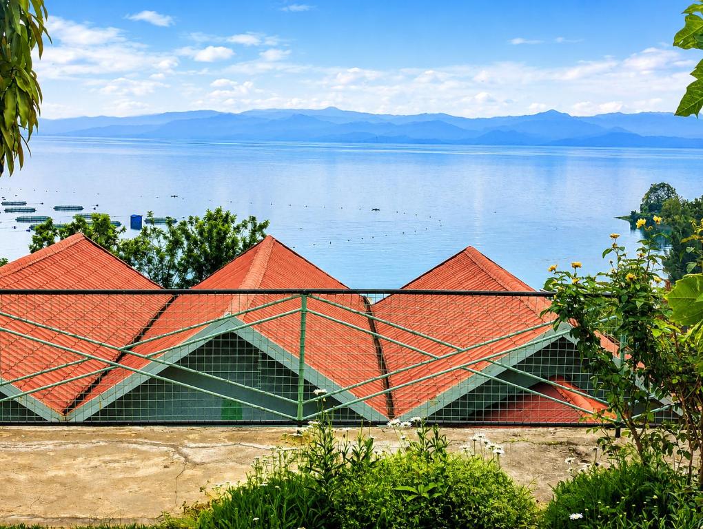 a building with an orange roof next to the water at Rusal Haven in Rubavu