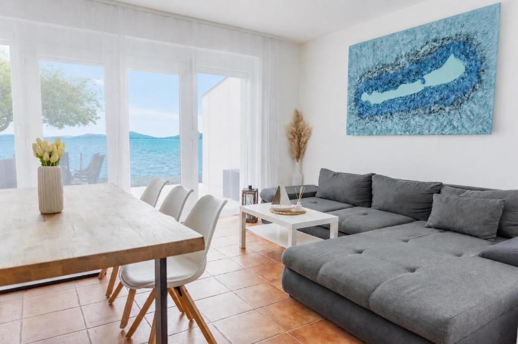 a living room with a couch and a table at BALATON A KERTBEN - BALATON IN THE GARDEN - Beachfront villas with beautiful view, private beach in Balatonfenyves