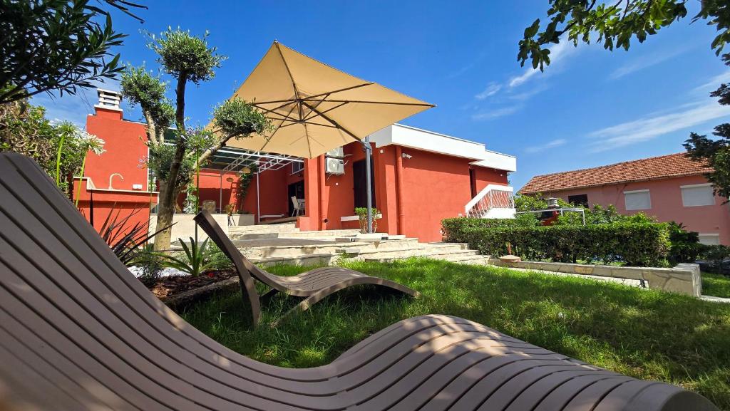 a park bench with an umbrella in the grass at Polaroid House '76 in Radovici