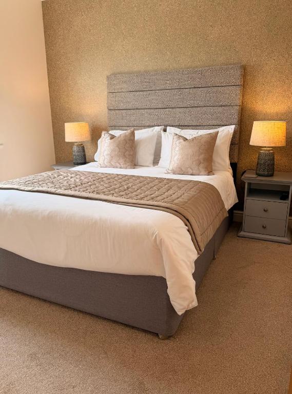 a bedroom with a large bed with two lamps at The Stokesay Boutique Townhouse Ludlow in Ludlow