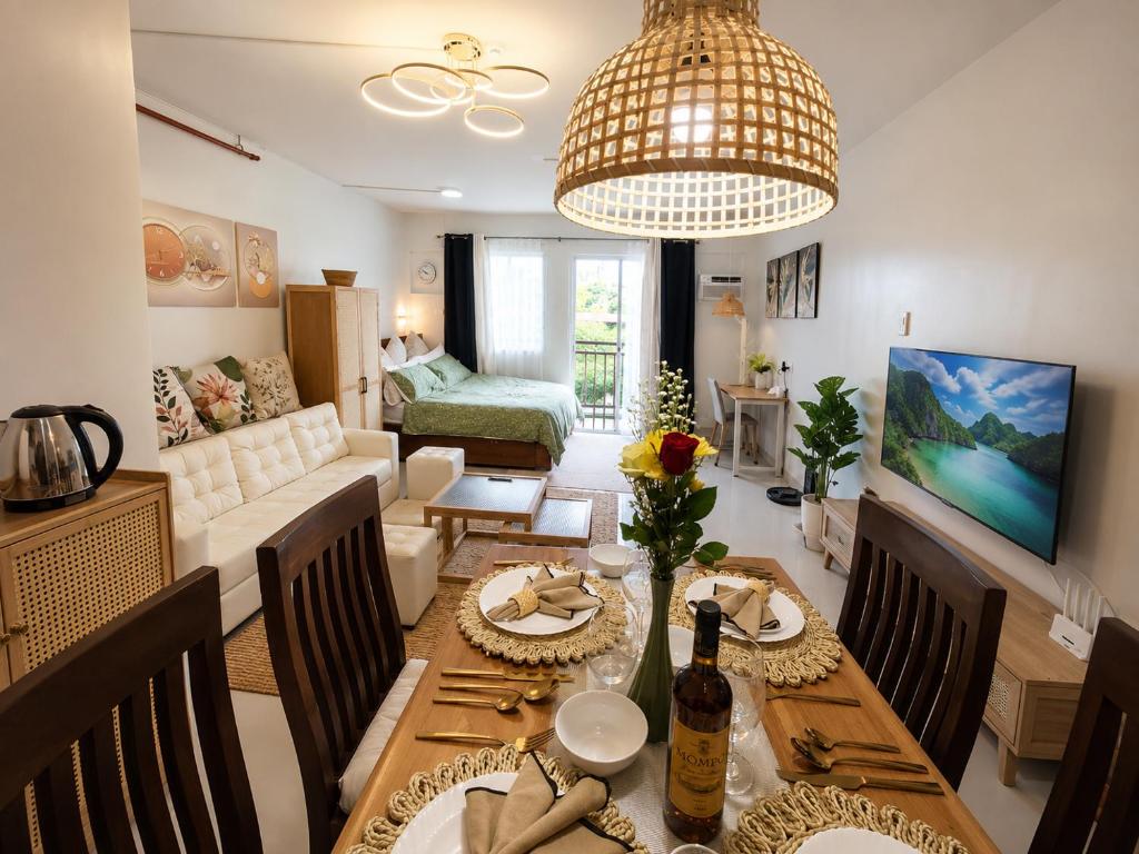 a living room with a table and a dining room at Spacious Studio w Pool, Gym, Smart Lock, Netflix in Puerto Princesa City