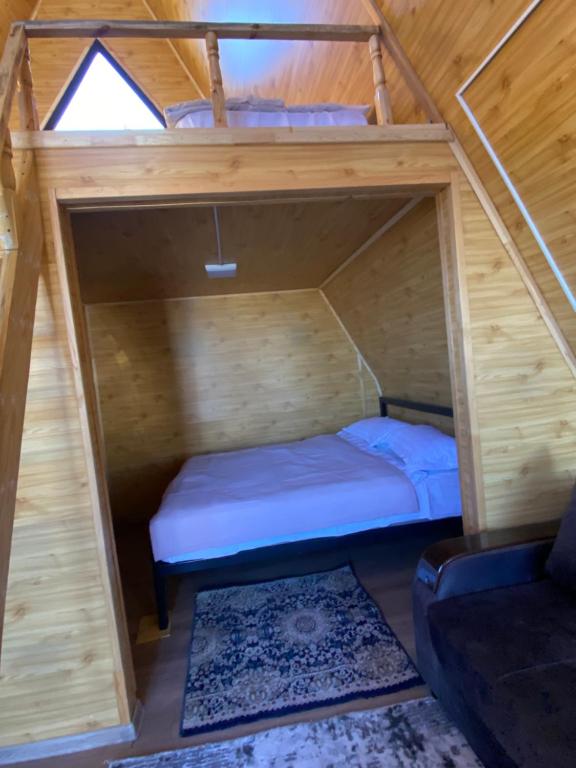 a bedroom with a bed in a wooden house at Baet Home in Bayetovka
