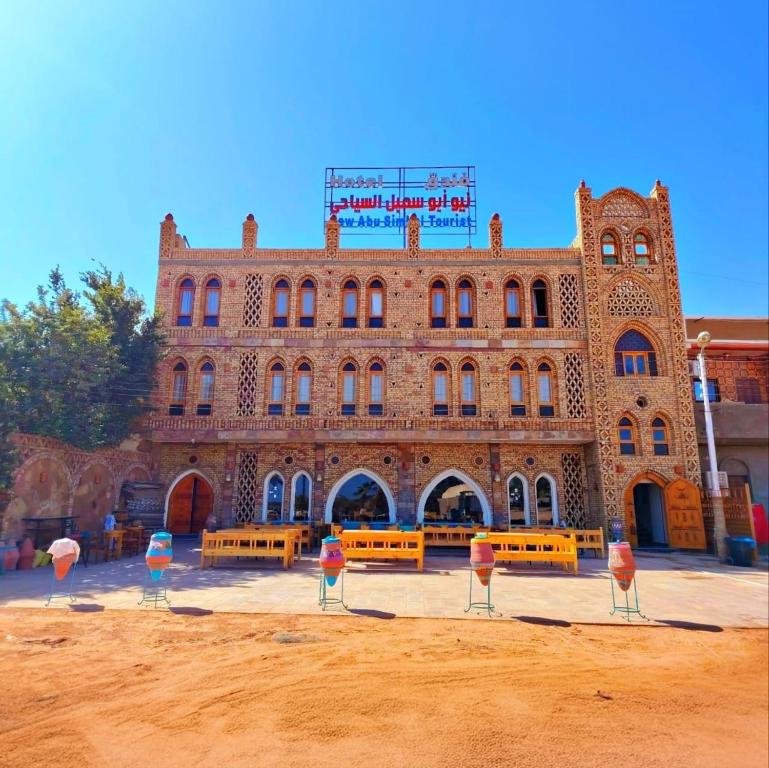 ein großes Backsteingebäude mit Bänken davor in der Unterkunft New Abu Simbel Tourist Hotel in Abu Simbel