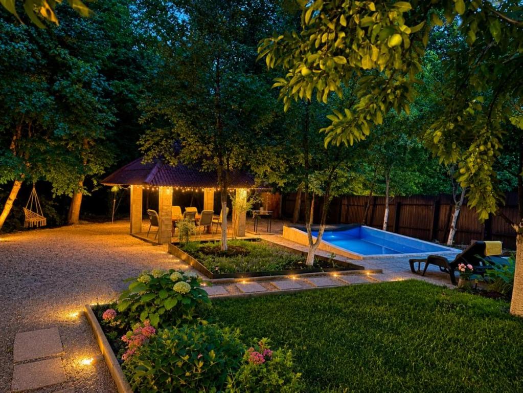 a backyard with a pool and a gazebo at night at VikendicaDM in Hrvačići