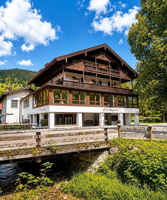 a large building on a bridge over a river at Hotel garni Königslinde - Wandern, Radeln, Skifahren & Genießen in Bayrischzell