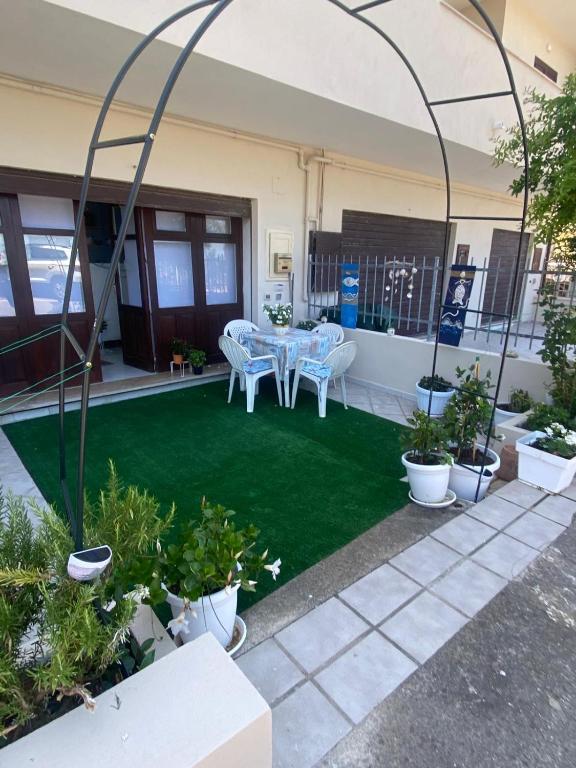 a patio with a table and chairs and plants at Green House in Briatico
