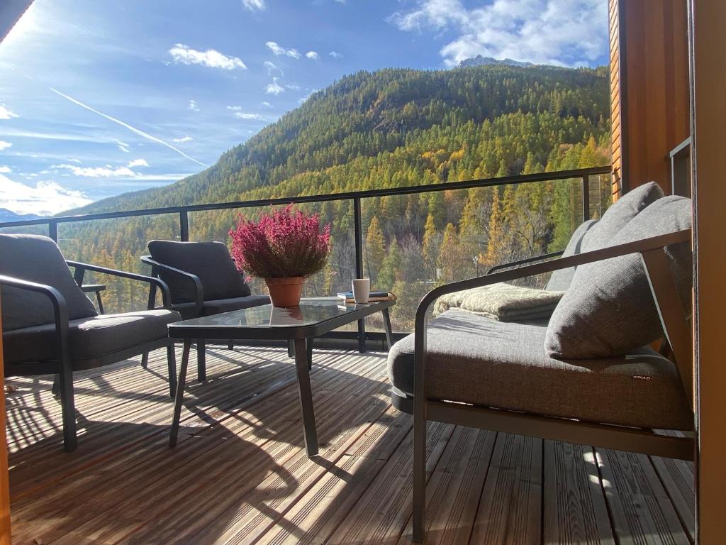 a balcony with a couch and a table with a view at Chalet Chante Guisane in Saint-Chaffrey